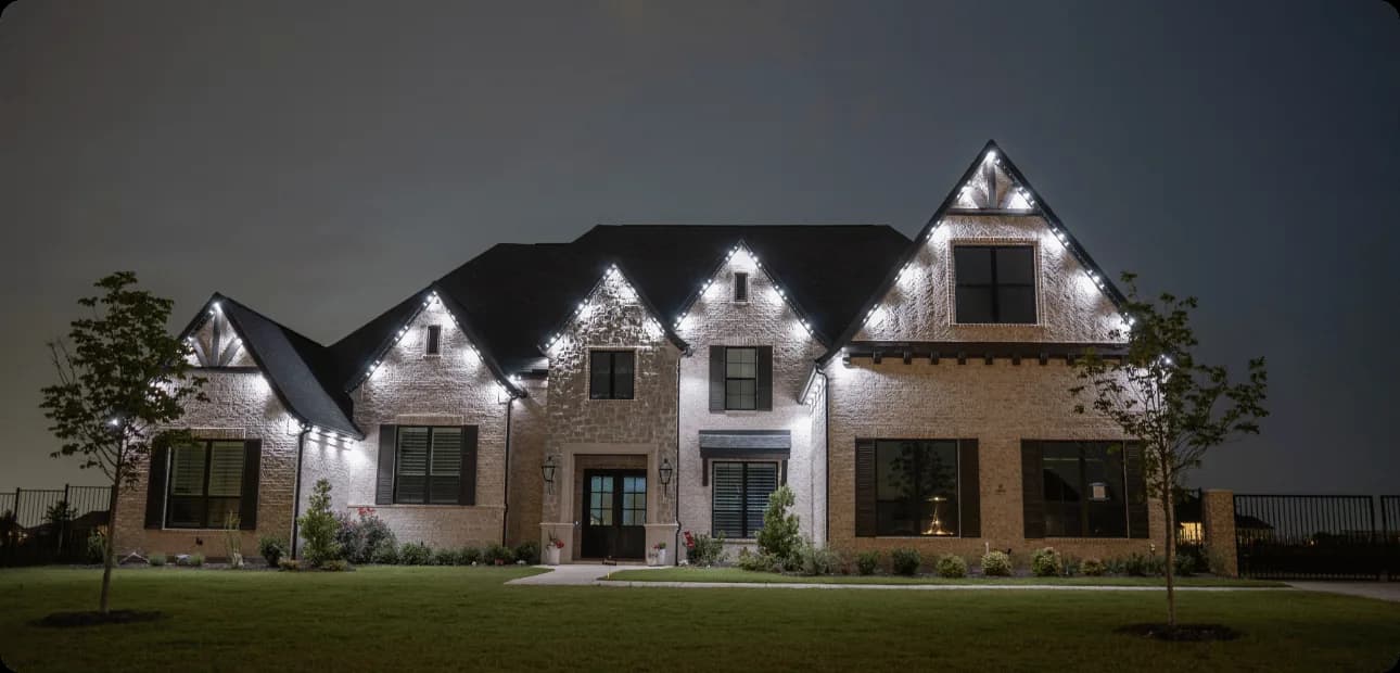 Twin Cities home with warm white roofline lighting — with Gray Duck permanent lighting on